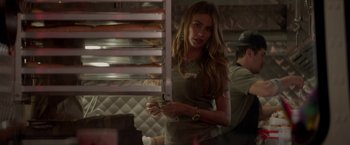Movie still from “Chef” (2014), directed by Jon Favreau – A beautiful woman holding a coffee cup in front of a rack of food; Medium shot, Over the shoulder angle
