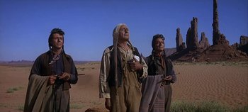Movie still from “Cheyenne Autumn” (1964), directed by John Ford – A group of men standing on top of a dirt field; Medium shot, Low angle