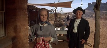 Movie still from “Cheyenne Autumn” (1964), directed by John Ford – A woman standing next to an older man in an outdoor setting; Medium shot, Low angle