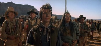 Movie still from “Cheyenne Autumn” (1964), directed by John Ford – A group of men standing next to each other on top of a hill; Medium shot, Low angle
