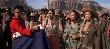 Movie still from “Cheyenne Autumn” (1964), directed by John Ford – A group of native american women standing next to each other; Medium shot, Over the shoulder angle