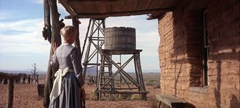 Movie still from “Cheyenne Autumn” (1964), directed by John Ford – A woman standing in front of a water tower; Wide shot, Low angle