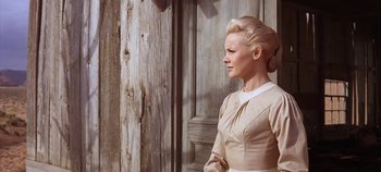 Movie still from “Cheyenne Autumn” (1964), directed by John Ford – A woman standing in front of a wooden door; Medium shot, Low angle