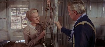 Movie still from “Cheyenne Autumn” (1964), directed by John Ford – A woman holding onto a rope with a man standing next to it; Medium shot, Low angle