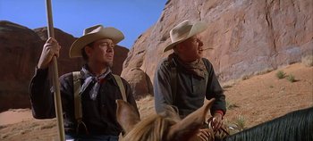 Movie still from “Cheyenne Autumn” (1964), directed by John Ford – Two men wearing cowboy hats and standing next to each other; Medium shot, Low angle