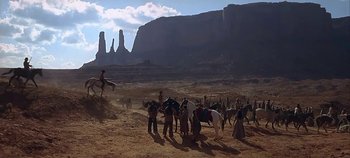 Movie still from “Cheyenne Autumn” (1964), directed by John Ford – A group of people standing on top of a dirt field; Extreme Wide shot, Low angle
