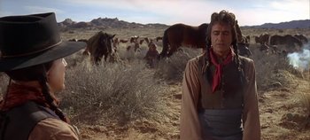 Movie still from “Cheyenne Autumn” (1964), directed by John Ford – A man standing next to a herd of horses; Medium shot, Over the shoulder angle