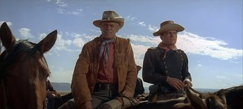 Movie still from “Cheyenne Autumn” (1964), directed by John Ford – Two men in cowboy hats sitting on top of a horse; Medium shot, Low angle
