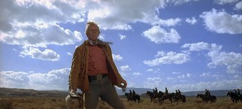 Movie still from “Cheyenne Autumn” (1964), directed by John Ford – A man in a cowboy outfit standing in the middle of a field; Medium shot, Low angle