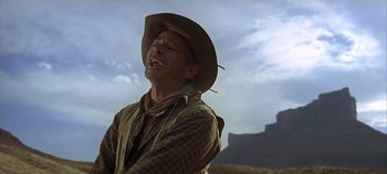 Movie still from “Cheyenne Autumn” (1964), directed by John Ford – A man wearing a cowboy hat standing in the desert; Medium shot, Low angle