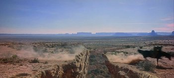 Movie still from “Cheyenne Autumn” (1964), directed by John Ford – An aerial view of a desert landscape with mountains in the background; Extreme Wide shot, Low angle