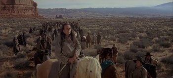 Movie still from “Cheyenne Autumn” (1964), directed by John Ford – A man sitting on top of a horse in the middle of a field; Wide shot, High angle