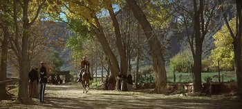 Movie still from “Cheyenne Autumn” (1964), directed by John Ford – A man riding a horse through a forest; Extreme Wide shot, Low angle