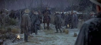 Movie still from “Cheyenne Autumn” (1964), directed by John Ford – A group of men on horses in the snow; Wide shot, High angle