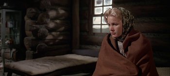Movie still from “Cheyenne Autumn” (1964), directed by John Ford – A young woman wrapped in a blanket sitting in a cabin; Close Up shot, Low angle