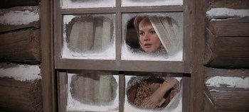 Movie still from “Cheyenne Autumn” (1964), directed by John Ford – A woman looking out of a window through a hole; Close Up shot, Low angle