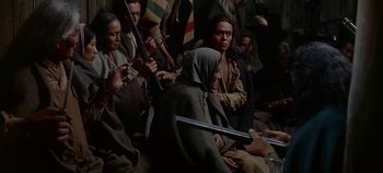 Movie still from “Cheyenne Autumn” (1964), directed by John Ford – A group of people sitting in a room holding weapons; Medium shot, High angle