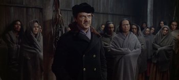 Movie still from “Cheyenne Autumn” (1964), directed by John Ford – A man wearing a black hat and a black coat; Medium shot, Over the shoulder angle