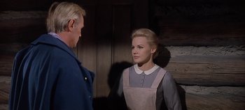 Movie still from “Cheyenne Autumn” (1964), directed by John Ford – A man and a woman standing next to each other in a room; Medium shot, Over the shoulder angle