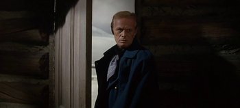 Movie still from “Cheyenne Autumn” (1964), directed by John Ford – A man standing in front of a wooden wall; Close Up shot, Low angle