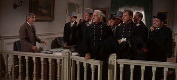 Movie still from “Cheyenne Autumn” (1964), directed by John Ford – A group of men sitting in front of each other in a courtroom; Medium shot, Low angle