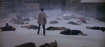 Movie still from “Cheyenne Autumn” (1964), directed by John Ford – A man standing in front of a group of dead bodies; Wide shot, High angle