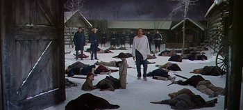 Movie still from “Cheyenne Autumn” (1964), directed by John Ford – A group of people laying on the ground in the middle of the snow; Wide shot, High angle