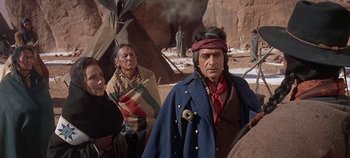 Movie still from “Cheyenne Autumn” (1964), directed by John Ford – A group of native americans standing in the desert; Medium shot, Over the shoulder angle