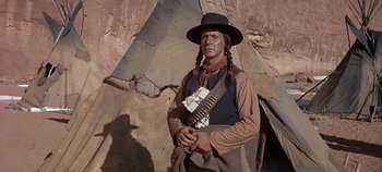 Movie still from “Cheyenne Autumn” (1964), directed by John Ford – An old man dressed as a native american holding a rifle; Medium shot, Low angle