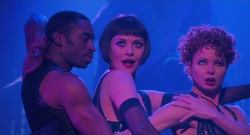 Movie still from “Chicago” (2002), directed by Rob Marshall – A group of people dancing in a blue room; Medium shot, Low angle