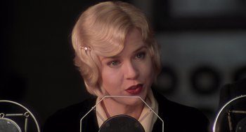 Movie still from “Chicago” (2002), directed by Rob Marshall – A woman with blonde curly hair is holding a microphone; Close Up shot, Low angle