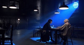 Movie still from “Chicago” (2002), directed by Rob Marshall – Two people are sitting at a table in a dark room; Wide shot, Over the shoulder angle