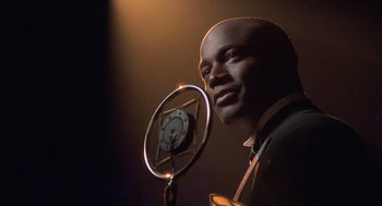 Movie still from “Chicago” (2002), directed by Rob Marshall – A man with a microphone in front of him; Close Up shot, Low angle