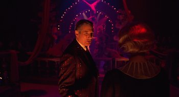 Movie still from “Chicago” (2002), directed by Rob Marshall – A man in a suit standing next to a woman in a red dress; Medium shot, Over the shoulder angle