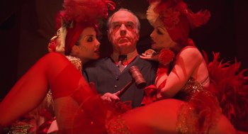 Movie still from “Chicago” (2002), directed by Rob Marshall – A man surrounded by two women holding a gavel; Medium shot, Low angle