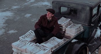 Movie still from “Chicago” (2002), directed by Rob Marshall – A man sitting in the back of a pick - up truck; Medium shot, High angle