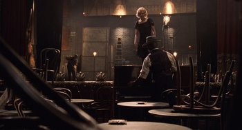 Movie still from “Chicago” (2002), directed by Rob Marshall – A man and a woman are in a dimly - lit room; Wide shot, Over the shoulder angle