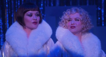 Movie still from “Chicago” (2002), directed by Rob Marshall – A couple of women standing next to each other on a stage; Close Up shot, Low angle