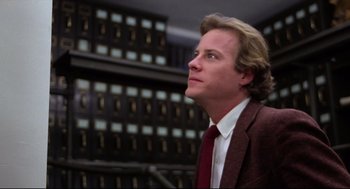 Movie still from “Chilly Scenes of Winter” (1979), directed by Joan Micklin Silver – A man wearing a suit and tie in front of a row of filing cabinets; Close Up shot, Low angle