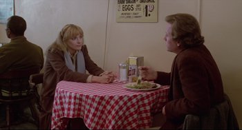 Movie still from “Chilly Scenes of Winter” (1979), directed by Joan Micklin Silver – Two people are sitting at a table with a plate of food; Medium shot, Over the shoulder angle