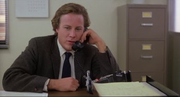 Movie still from “Chilly Scenes of Winter” (1979), directed by Joan Micklin Silver – A man sitting at a desk talking on a phone; Close Up shot, Low angle