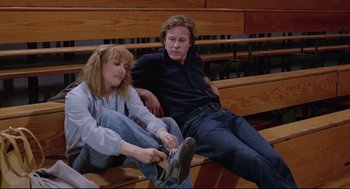 Movie still from “Chilly Scenes of Winter” (1979), directed by Joan Micklin Silver – A man and a woman sitting on top of a wooden bench; Medium shot, Low angle