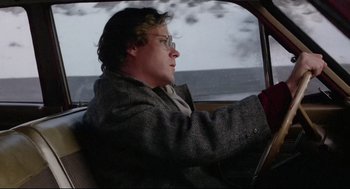 Movie still from “Chilly Scenes of Winter” (1979), directed by Joan Micklin Silver – A man driving a car in the rain; Medium shot, Low angle