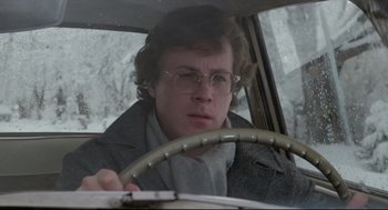 Movie still from “Chilly Scenes of Winter” (1979), directed by Joan Micklin Silver – A man driving a car in the snow wearing glasses; Close Up shot, Low angle