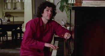 Movie still from “Chilly Scenes of Winter” (1979), directed by Joan Micklin Silver – A man sitting at a piano in a living room; Medium shot, Low angle