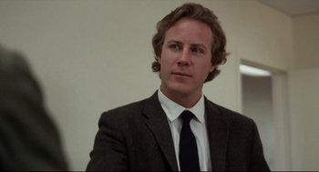 A man in a suit and tie looking at the camera