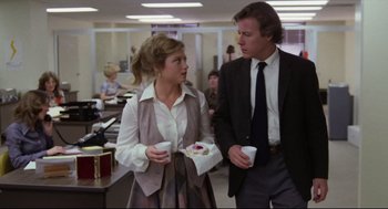 Movie still from “Chilly Scenes of Winter” (1979), directed by Joan Micklin Silver – A man and a woman standing next to each other in an office; Medium shot, Over the shoulder angle