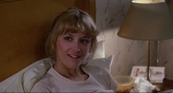 Movie still from “Chilly Scenes of Winter” (1979), directed by Joan Micklin Silver – A woman sitting in a chair smiling for the camera; Close Up shot, Over the shoulder angle