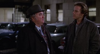 Movie still from “Chilly Scenes of Winter” (1979), directed by Joan Micklin Silver – A man wearing a hat and a tie talking to another man; Medium shot, Over the shoulder angle