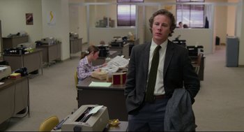 Movie still from “Chilly Scenes of Winter” (1979), directed by Joan Micklin Silver – A man standing in an office next to a desk; Medium shot, Low angle